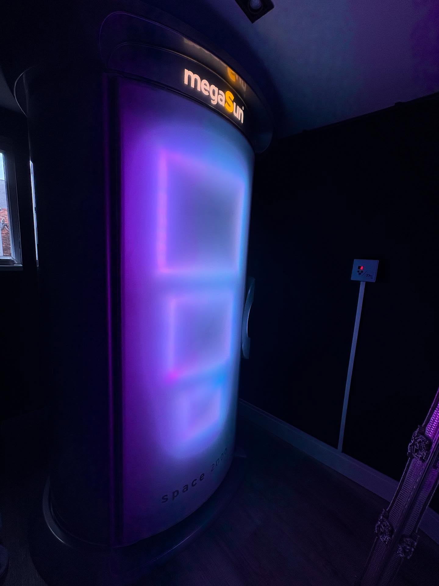 Radiant's megaSun Space 2000 stand up sunbed illuminated blue and violet