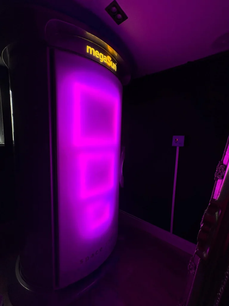 Radiant's megaSun Space 2000 stand up sunbed glowing magenta inside the Ashton salon